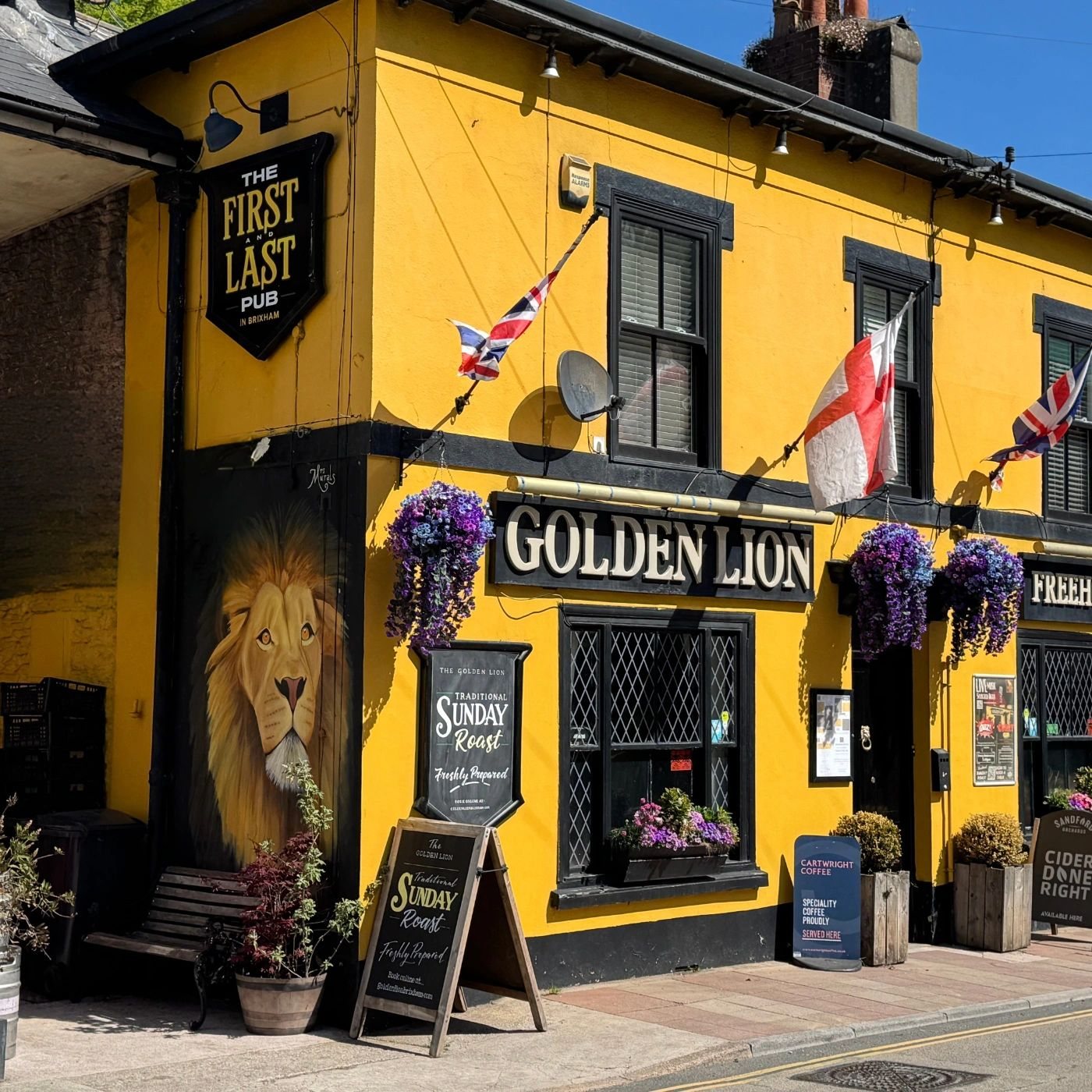 Yellow and black Golden Lion pub exterior with lion mural